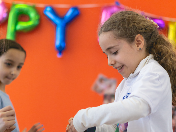 A grinning party guest in front of foil balloon letters