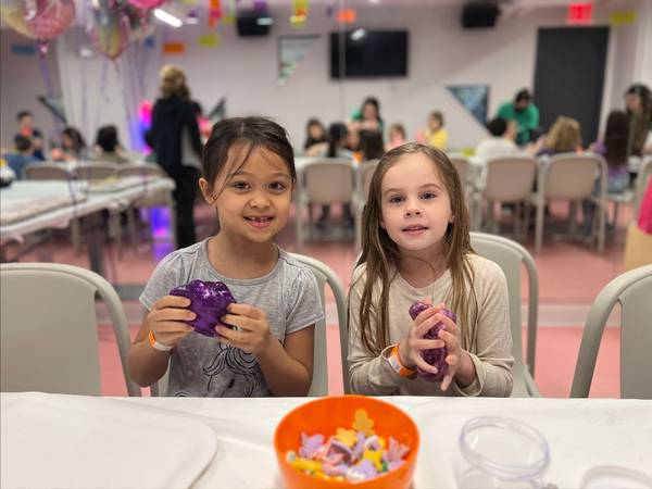 Two girls with the glittery purple slime that goes into their squishies