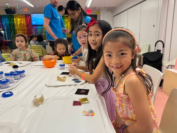 Party leaders helping guests at the glitter-tile table