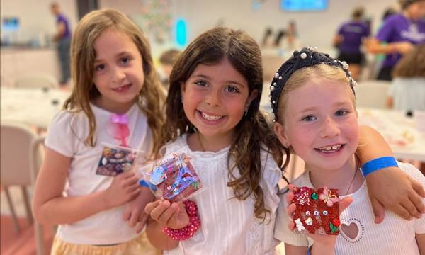 Three friends arm-in-arm holding their keepsakes