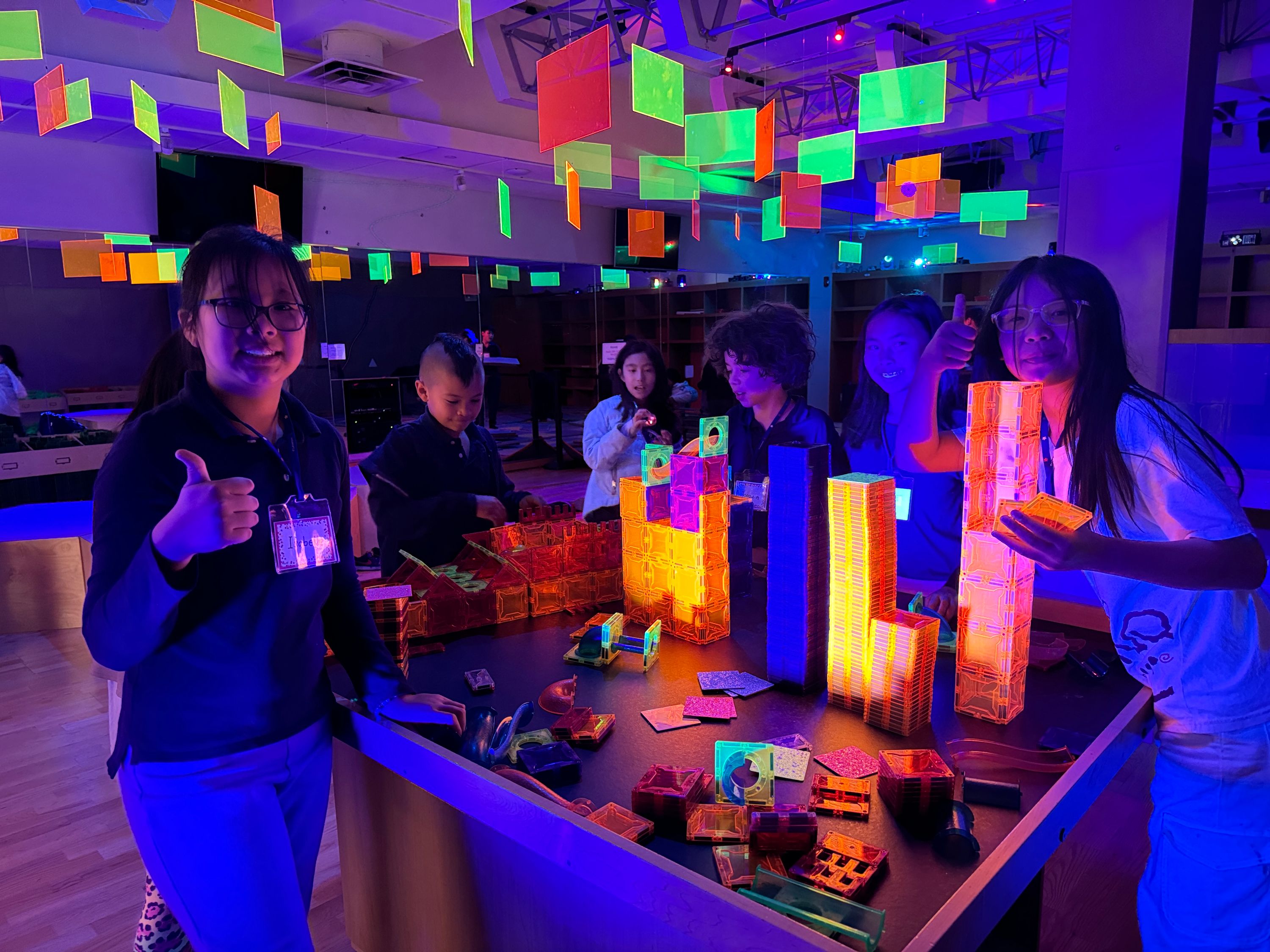 Campers building under blacklight in the glow room at Genius Gems NYC
