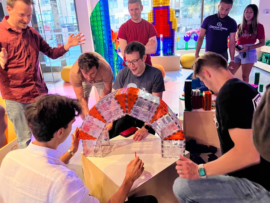 Adults building a magnetic-tile arch together at Genius Gems NYC